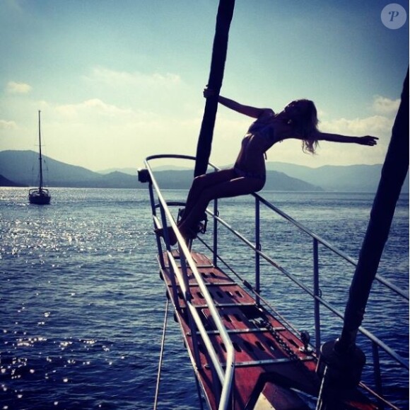 Poppy Delevingne, en vacances, se dore la pilule sur un bateau. Août 2014.