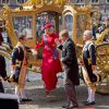 Le roi Willem-Alexander aide son épouse la reine Maxima des Pays-Bas, en robe Valentino, lors de leur arrivée au Parlement à La Haye pour le Prinsjesdag, la cérémonie d'ouverture de l'année parlementaire, le 16 septembre 2014