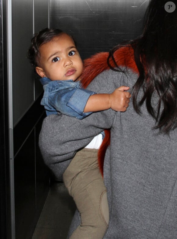 North West, 1 an, arrive à l'aéroport LAX dans les bras de sa mère, Kim Kardashian. Los Angeles, le 22 septembre 2014.