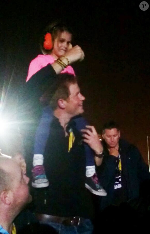 Le prince Harry avec la petite Isabelle Nixon sur ses épaules pendant le concert des Foo Fighters lors de la clôture des Invictus Games, le 14 septembre 2014 à Londres.