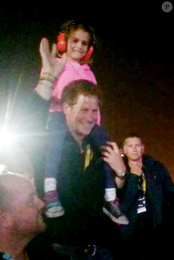 Le prince Harry avec la petite Isabelle Nixon sur ses épaules pendant le concert des Foo Fighters lors de la clôture des Invictus Games, le 14 septembre 2014 à Londres.