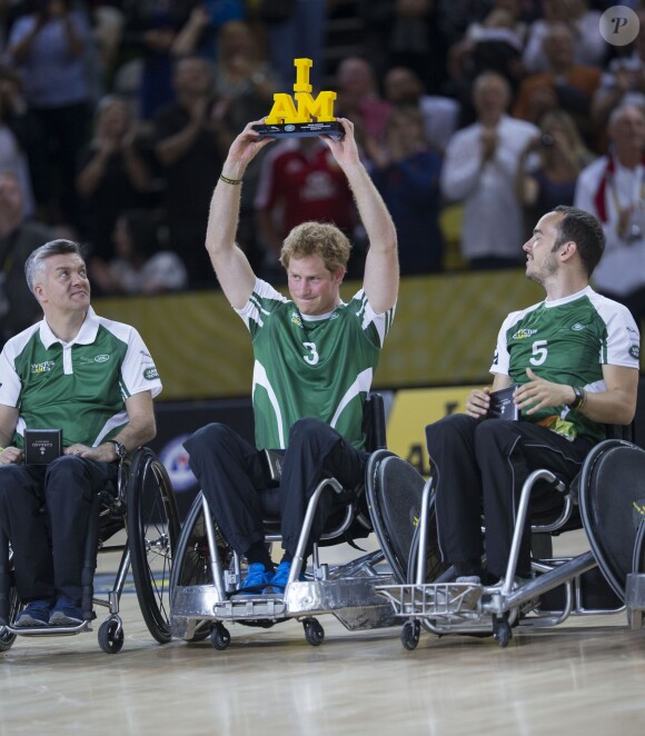 Le prince Harry soulevant un trophée des Invictus Games lors d'une démonstration de rugby en fauteuil roulant le 12 septembre 2014