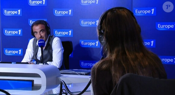 Carla Bruni-Sarkozy face à Nikos Aliagas dans son émission "Sortez du cadre" sur Europe 1. Octobre 2014. La chanteuse a fait de l'humour concernant une question sur le football.