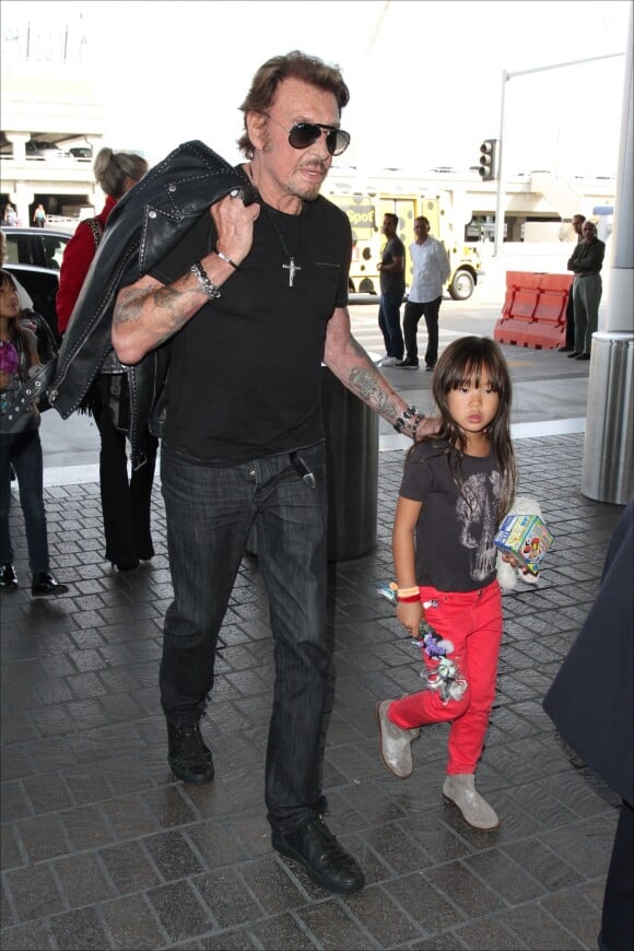 Johnny Hallyday quitte Los Angeles en famille pour rejoindre Paris, le 14 octobre 2014. Le rocker était accompagné de sa femme Laeticia, de ses filles Jade et Joy ainsi que la grand-mère de son épouse Eliette et de son chien Santos. 