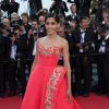 Freida Pinto, radieuse en robe rouge Oscar de la Renta, foule le tapis rouge du Festival de Cannes. Le 18 mai 2014.