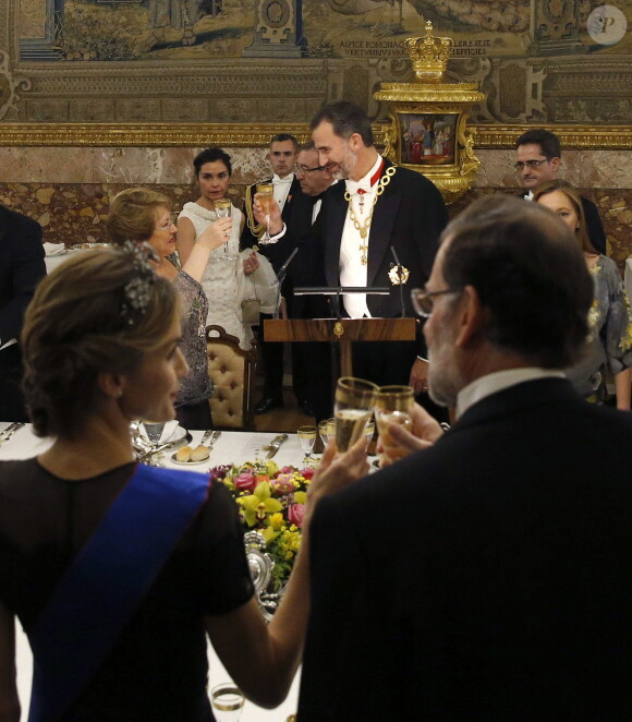 Letizia d'Espagne, de dos, trinque avec le chef du gouvernement Mariano Rajoy tandis que Felipe en fait autant avec Michelle Bachelet, le 29 octobre 2014 au palais du Pardo, à Madrid.