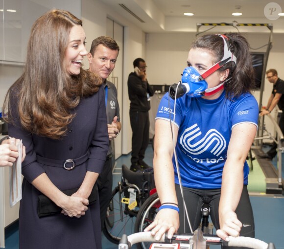 Kate Middleton, enceinte, a tenté de communiquer avec la jeune golfeuse Emma Allen en plein test d'effort alors qu'elle visitait le 12 novembre 2014 le GSK Human Performance Lab à Brentford (ouest de Londres) dans le cadre de son patronage de SportsAid.