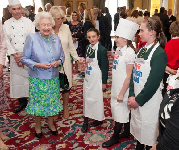 La reine Elizabeth II et Camilla Parker Bowles rencontrant en juin 2012 des lauréats du concours 'Cuisinez pour la reine' à Buckingham Palace