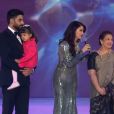 Aishwarya Rai arrive sur la scène du concours Miss Monde à Londres le 14 décembre 2014 avec sa fille, son mari et sa mère