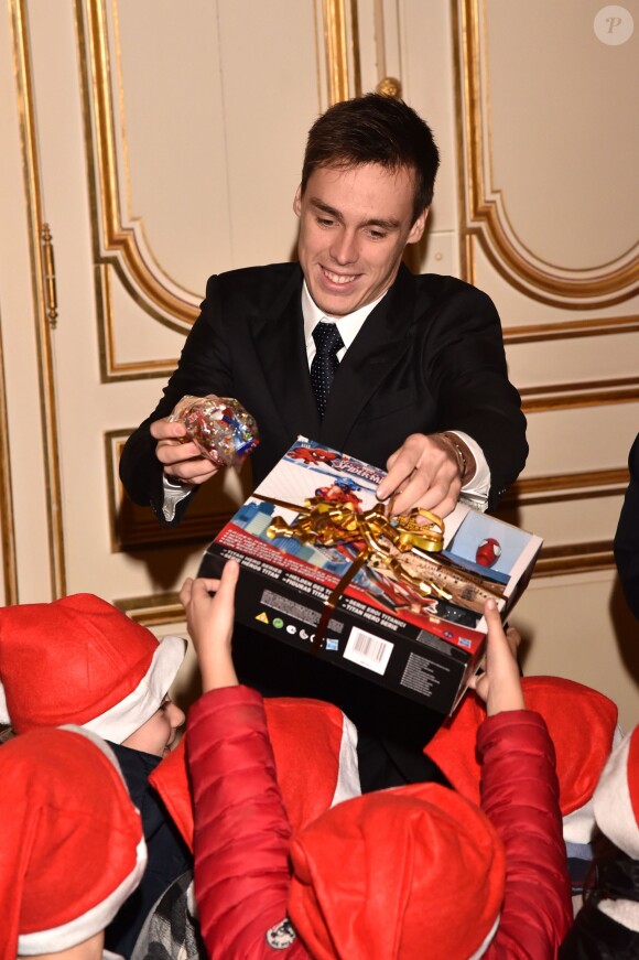 Louis Ducruet en pleine distribution de cadeaux de noël avec son oncle le prince Albert II le 17 décembre 2014 au palais princier de Monaco