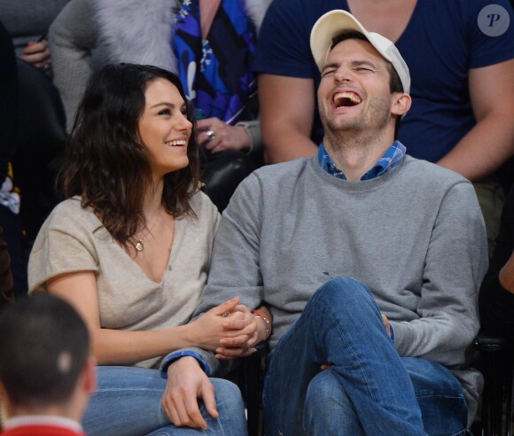 Mila Kunis et son fiancé Ashton Kutcher très amoureux et très complices au match de basket des Lakers à Los Angeles, le 19 décembre 2014.