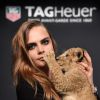 Cara Delevingne nouvelle ambassadrice de la marque Tag Heuer avec un lionceau dans les bras le 23 janvier 2015 à Paris au Palais des Beaux-Arts.