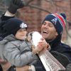 Tom Brady et son fils Benjamin (5 ans) fêtent la victoire de son équipe les New England Patriots au Super Bowl lors d'une parade à Boston, le 4 février 2015 en brandissant le trophée pendant que la foule applaudit l'équipe.