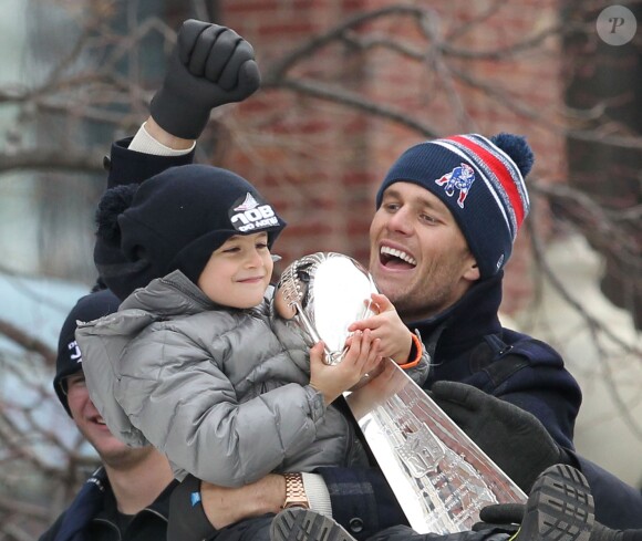 Tom Brady et son fils Benjamin (5 ans) fêtent la victoire de son équipe les New England Patriots au Super Bowl lors d'une parade à Boston, le 4 février 2015 en brandissant le trophée pendant que la foule applaudit l'équipe.