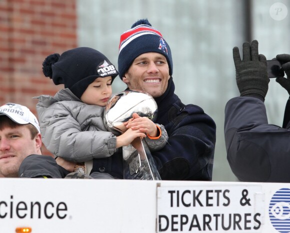 Tom Brady et son fils Benjamin fêtent la victoire des New England Patriots au Super Bowl lors d'une parade à Boston, le 4 février 2015 en brandissant le trophée pendant que la foule applaudit l'équipe.