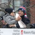  Tom Brady et son fils Benjamin f&ecirc;tent la victoire de son &eacute;quipe les New England Patriots au Super Bowl lors d'une parade &agrave; Boston, le 4 f&eacute;vrier 2015 en brandissant le troph&eacute;e pendant que la foule applaudit l'&eacute;quipe. 