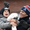 Tom Brady et son fils Benjamin fêtent la victoire de son équipe les New England Patriots au Super Bowl lors d'une parade à Boston, le 4 février 2015 en brandissant le trophée pendant que la foule applaudit l'équipe.