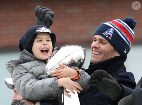 Tom Brady et son fils Benjamin fêtent la victoire de son équipe les New England Patriots au Super Bowl lors d'une parade à Boston, le 4 février 2015 en brandissant le trophée pendant que la foule applaudit l'équipe.