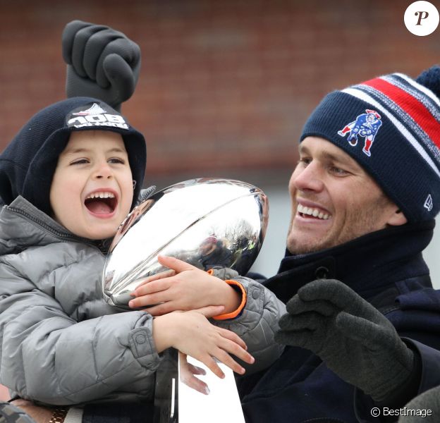Tom Brady et son fils Benjamin fêtent la victoire de son équipe les New England Patriots au Super Bowl lors d'une parade à Boston, le 4 février 2015 en brandissant le trophée pendant que la foule applaudit l'équipe.