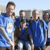 Geoffroy Roux de Bézieux aide un handicapé au départ du " Semi-Marathon de Paris 2015 " à Paris, le 8 mars 2015.