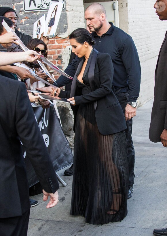 Kim Kardashian, escortée par son garde du corps Pascal Duvier, signe des autographes à son arrivée aux studios de l'émission Jimmy Kimmel Live! à Hollywood, le 30 avril 2015.