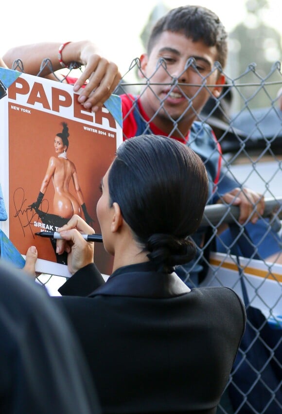 Kim Kardashian signe un exemplaire du numéro d'hiver 2015 du magazine Paper à son arrivée aux studios de l'émission Jimmy Kimmel Live!. Hollywood, le 30 avril 2015.