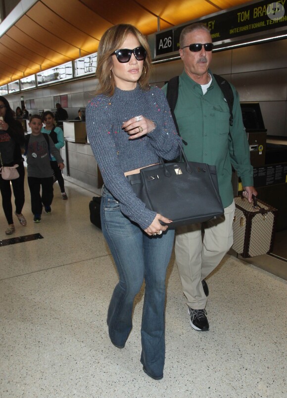 Un clown jette des confettis sur Jennifer Lopez à son arrivée à l'aéroport de Los Angeles, le 26 mai 2015.  
