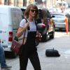 Taylor Swift se promène à New York, le 28 mai 2015. Elle porte une salopette noire, un tee-shirt court et un sac de la marque Gucci.