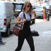 Taylor Swift se promène à New York, le 28 mai 2015. Elle porte une salopette noire, un tee-shirt court et un sac de la marque Gucci. 