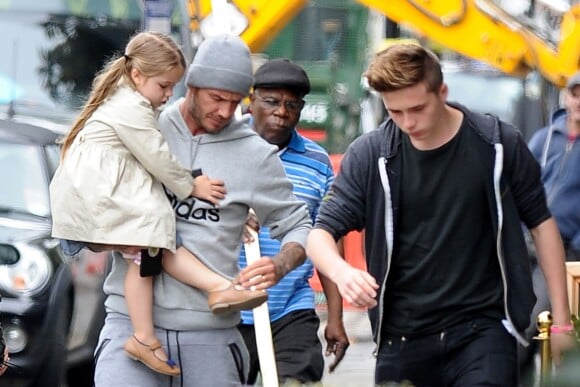 Exclusif - David Beckham, affairé sur les chaussures de sa fille Harper devant son fils Brooklyn à la sortie du restaurant Grainger & Co Notting Hill, le 22 juin 2015 à Londres