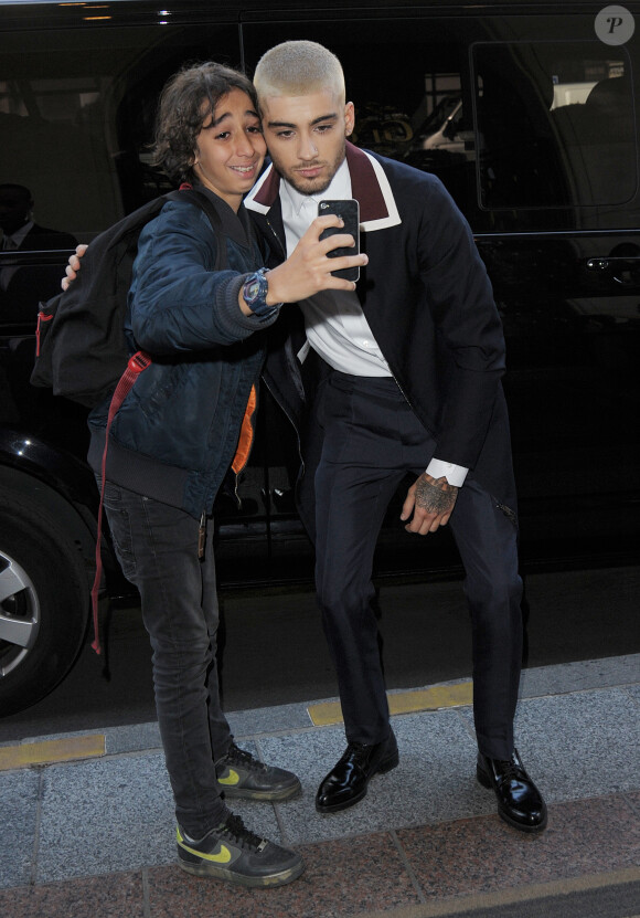 Zayn Malik pose avec ses fans devant son hôtel parisien le 24 juin 2015. Il vient d'assister au défilé Valentino.