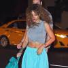 Rihanna arrive au restaurant Da Silvano à New York, habillée d'un t-shirt gris noué au ventre, d'un pantalon bleu turquoise Acne Studios et de sandales Christian Dior, assorties à son rouge à lèvres. Le 11 juillet 2015.