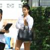Selena Gomez, surprise à Los Angeles, porte un chemisier blanc Equipment, un mini-short en jean, un sac noir Prada (modèle Saffiano Lux) et des bottines Saint Laurent. Le 9 juillet 2015.