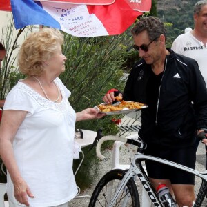 L'ancien président de la République, Nicolas Sarkozy, se fait offrir des beignets de fleurs de courgette à l'auberge de Ginette lors d'une sortie en vélo dans la forêt des Maures Le Lavandou, le 7 juillet 2014.