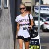 Kaley Cuoco porte un t-shirt à message ("Never ending Fun") et une besace à motif "tête de mort" à Beverly Hills le 13 juillet 2015. 