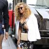 Beyoncé Knowles se rend au siège de Parkwood Entertainment à New York, habillée d'un blazer blanc porté à l'italienne, d'une robe noire imprimée de fleurs de cerisier Dolce & Gabbana et de sandales Stuart Weitzman (modèle Nudist). Des lunettes Ray-Ban (collection Clubmaster) et un sac beige Dannijo complètent sa tenue. Le 27 juillet 2015.