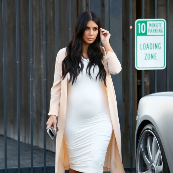 Kim Kardashian quitte un studio de tournage à Van Nuys, Los Angeles, habillée d'une veste nude Maison Margiela, d'une robe blanche Wolford et de sandales Manolo Blahnik (modèle Chaos). Le 27 juillet 2015.