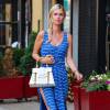 Nicky Hilton se promène à New York, habillée d'une robe bleue rayée Reformation, un sac blanc Goyard et des sandales entrelacées en cuir. Le 29 juillet 2015.
