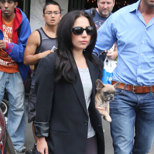 Lady Gaga se promène avec son chien Koji, dans ses bras, dans les rues de New York. Le 12 mai 2015  