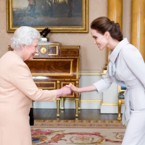 Angelina Jolie se voit remettre l'insigne de l'Honorary Dame Grand Cross of the Most Distinguished Order of St Michael and St George par la reine Elizabeth II à Buckingham Palace, Londres, le 10 octobre 2014.