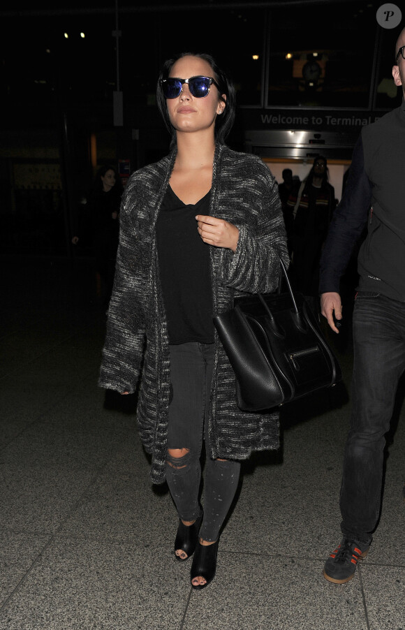 Demi Lovato arrive accompagnée de son garde du corps à l'aéroport de Heathrow à Londres, le 7 septembre 2015