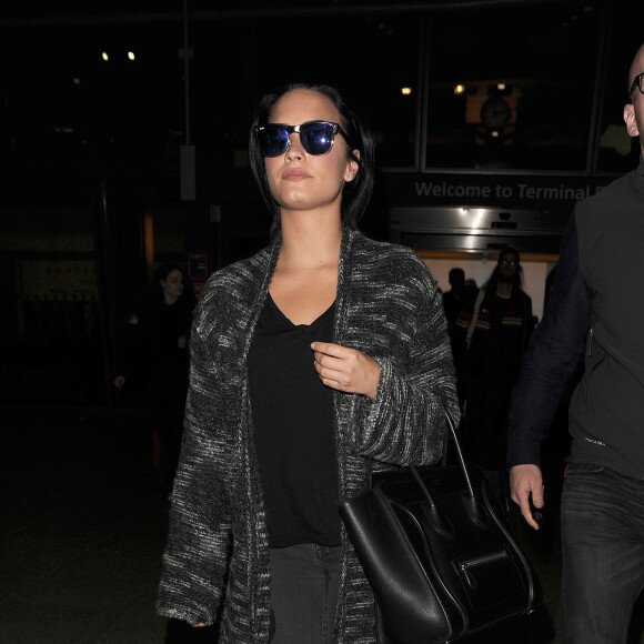 Demi Lovato arrive accompagnée de son garde du corps à l'aéroport de Heathrow à Londres, le 7 septembre 2015