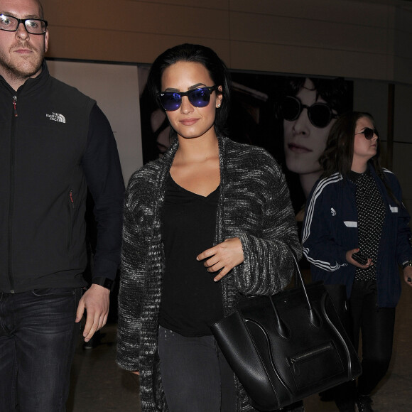 Demi Lovato arrive accompagnée de son garde du corps à l'aéroport de Heathrow à Londres, le 7 septembre 2015