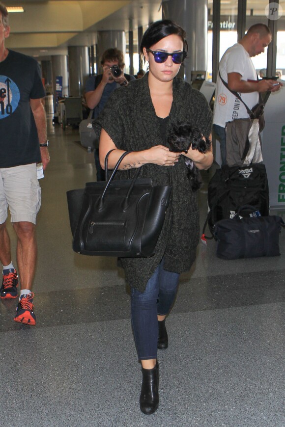 Demi Lovato et son chien à l'aéroport de Los Angeles, le 28 septembre 2015. La chanteuse vient de perdre son grand-père