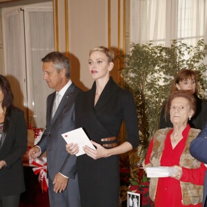 La princesse Charlene a distribué avec le prince Albert II de Monaco, le 17 novembre 2015, à l'avant-veille de la Fête nationale, des colis de la Croix-Rouge monegasque aux personnes âgées à Monaco le 17 novembre 2015. En prime cette année, une photo du couple princier posant avec ses enfants le prince héréditaire Jacques et la princesse Gabriella. © Jean-Charles Vinaj / Pool restreint / Bestimage