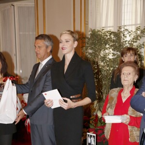 La princesse Charlene a distribué avec le prince Albert II de Monaco, le 17 novembre 2015, à l'avant-veille de la Fête nationale, des colis de la Croix-Rouge monegasque aux personnes âgées à Monaco le 17 novembre 2015. En prime cette année, une photo du couple princier posant avec ses enfants le prince héréditaire Jacques et la princesse Gabriella. © Jean-Charles Vinaj / Pool restreint / Bestimage