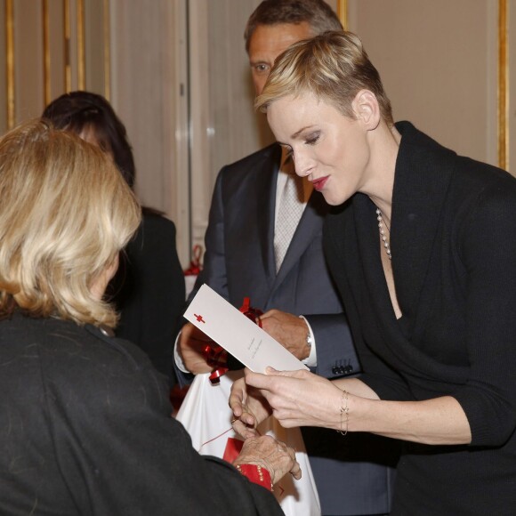 La princesse Charlene a distribué avec le prince Albert II de Monaco, le 17 novembre 2015, à l'avant-veille de la Fête nationale, des colis de la Croix-Rouge monegasque aux personnes âgées à Monaco le 17 novembre 2015. En prime cette année, une photo du couple princier posant avec ses enfants le prince héréditaire Jacques et la princesse Gabriella. © Jean-Charles Vinaj / Pool restreint / Bestimage