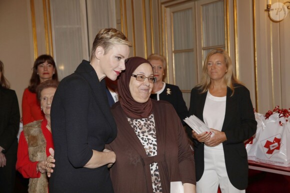 La princesse Charlene a distribué avec le prince Albert II de Monaco, le 17 novembre 2015, à l'avant-veille de la Fête nationale, des colis de la Croix-Rouge monegasque aux personnes âgées à Monaco le 17 novembre 2015. En prime cette année, une photo du couple princier posant avec ses enfants le prince héréditaire Jacques et la princesse Gabriella. © Jean-Charles Vinaj / Pool restreint / Bestimage