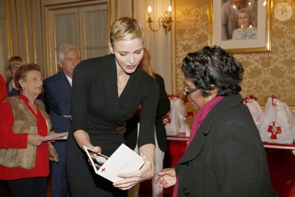 La princesse Charlene a distribué avec le prince Albert II de Monaco, le 17 novembre 2015, à l'avant-veille de la Fête nationale, des colis de la Croix-Rouge monegasque aux personnes âgées à Monaco le 17 novembre 2015. En prime cette année, une photo du couple princier posant avec ses enfants le prince héréditaire Jacques et la princesse Gabriella. © Jean-Charles Vinaj / Pool restreint / Bestimage