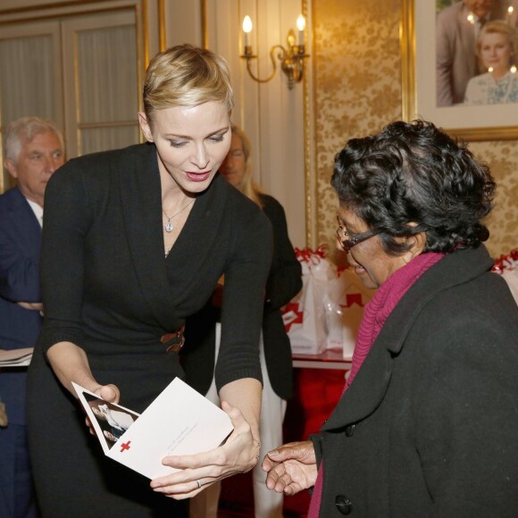 La princesse Charlene a distribué avec le prince Albert II de Monaco, le 17 novembre 2015, à l'avant-veille de la Fête nationale, des colis de la Croix-Rouge monegasque aux personnes âgées à Monaco le 17 novembre 2015. En prime cette année, une photo du couple princier posant avec ses enfants le prince héréditaire Jacques et la princesse Gabriella. © Jean-Charles Vinaj / Pool restreint / Bestimage